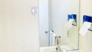 A bathroom with a sink, mirror, and towel rack.