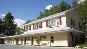 A two-story building with a flat roof and a covered front porch.