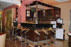 A bar area with a counter, stools, and a wine rack. - Archi Hotel-Apartment (Addis Ababa)