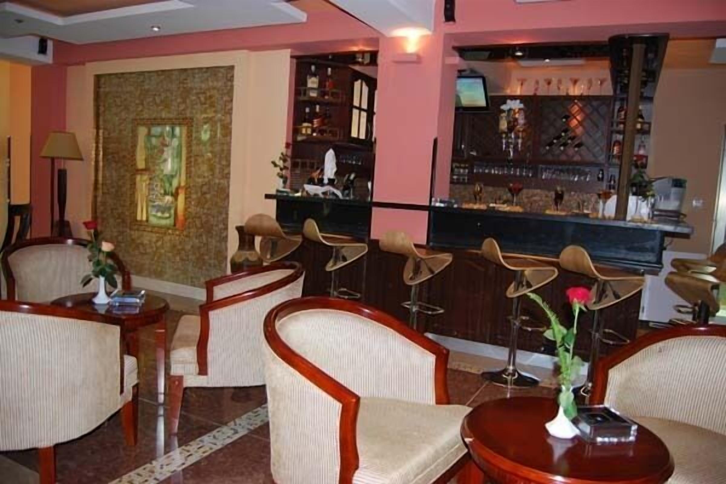 A bar area with a counter, bar stools, and a television screen.