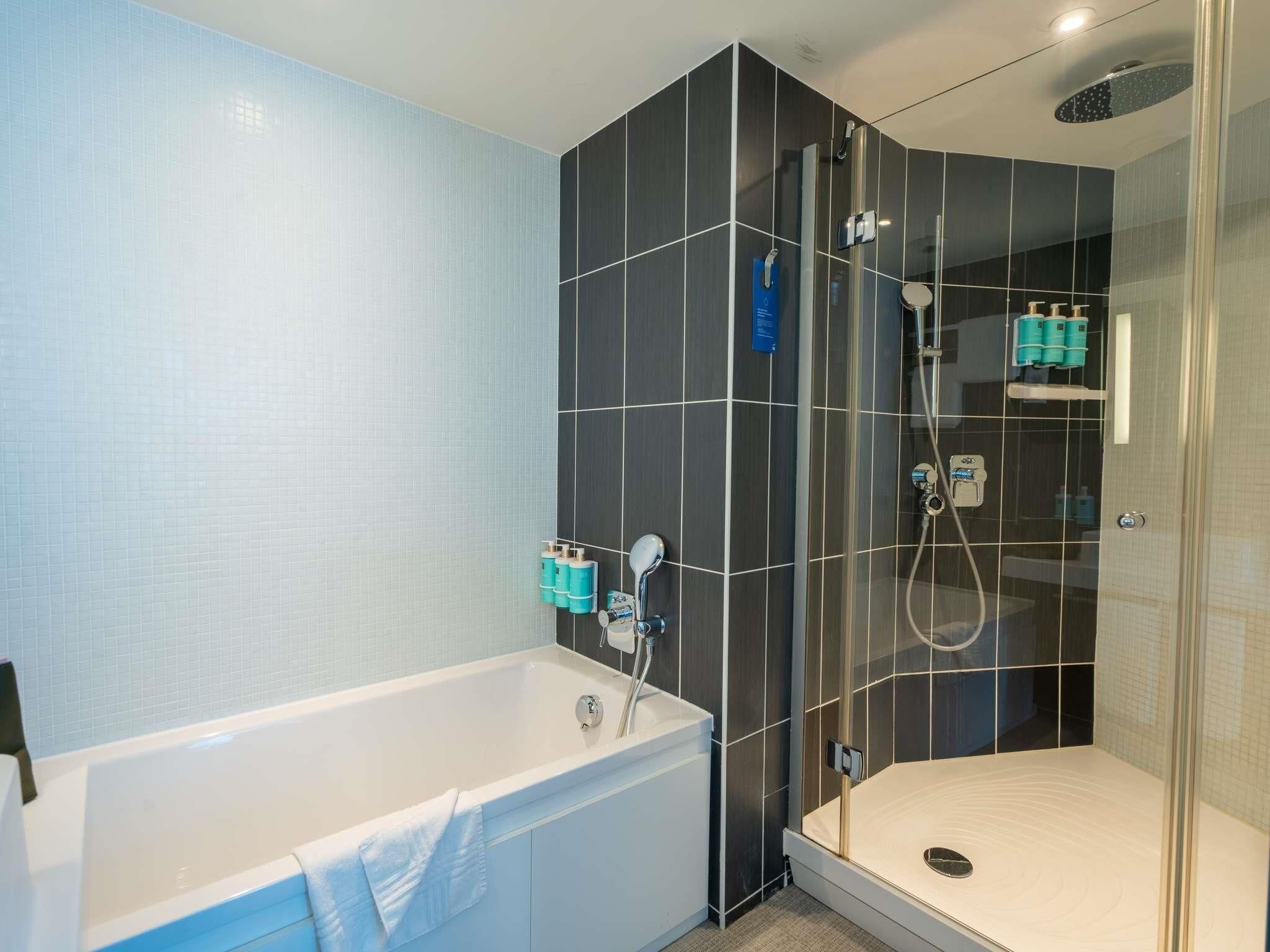 Ein modernes Badezimmer mit Badewanne, Dusche und einer separaten Duschkabine.