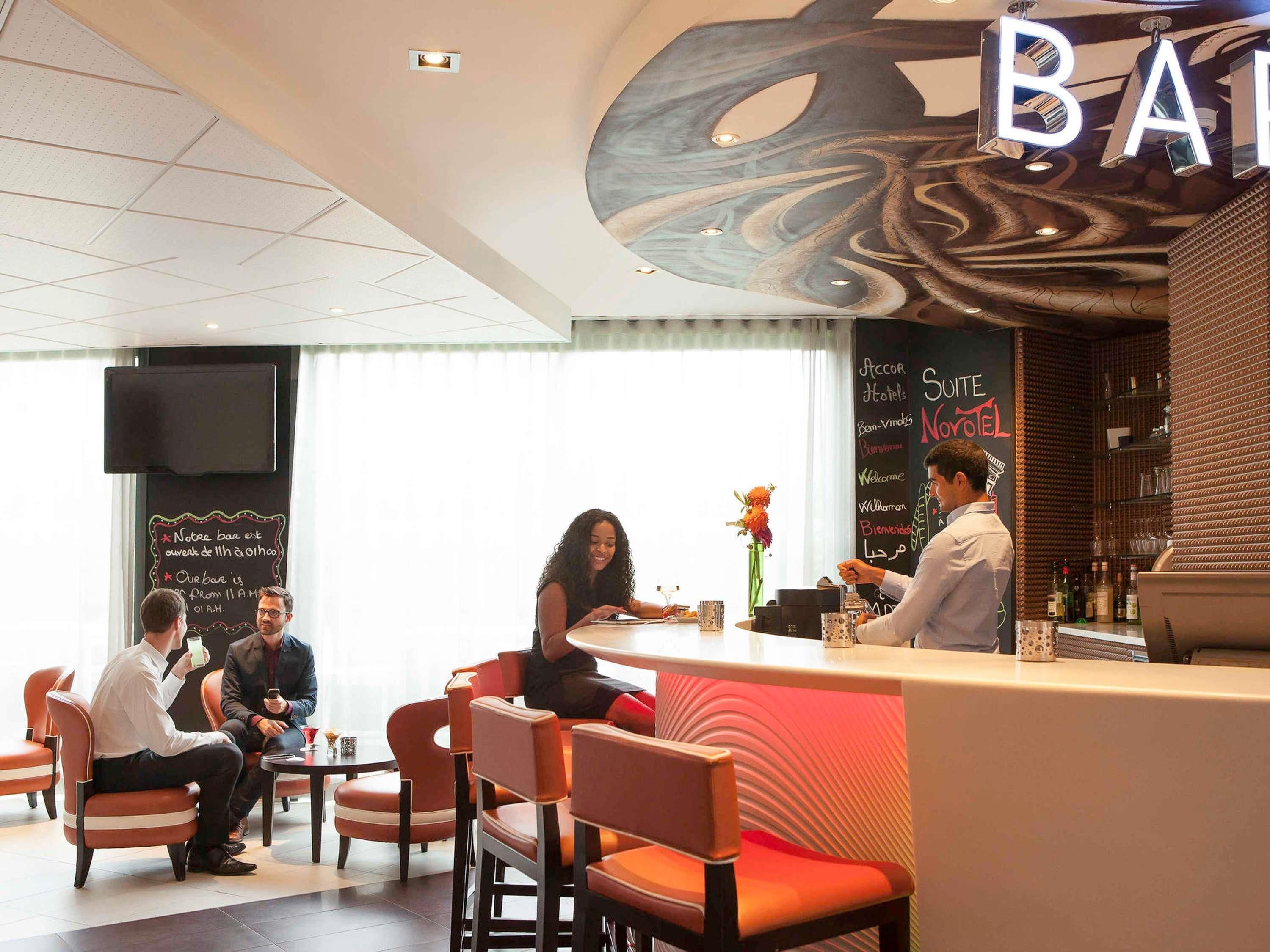 A modern bar area with a seating section, a chalkboard menu, and a bar counter.