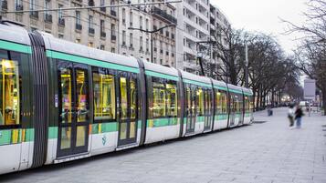 A tram on a city street with buildings in the background.