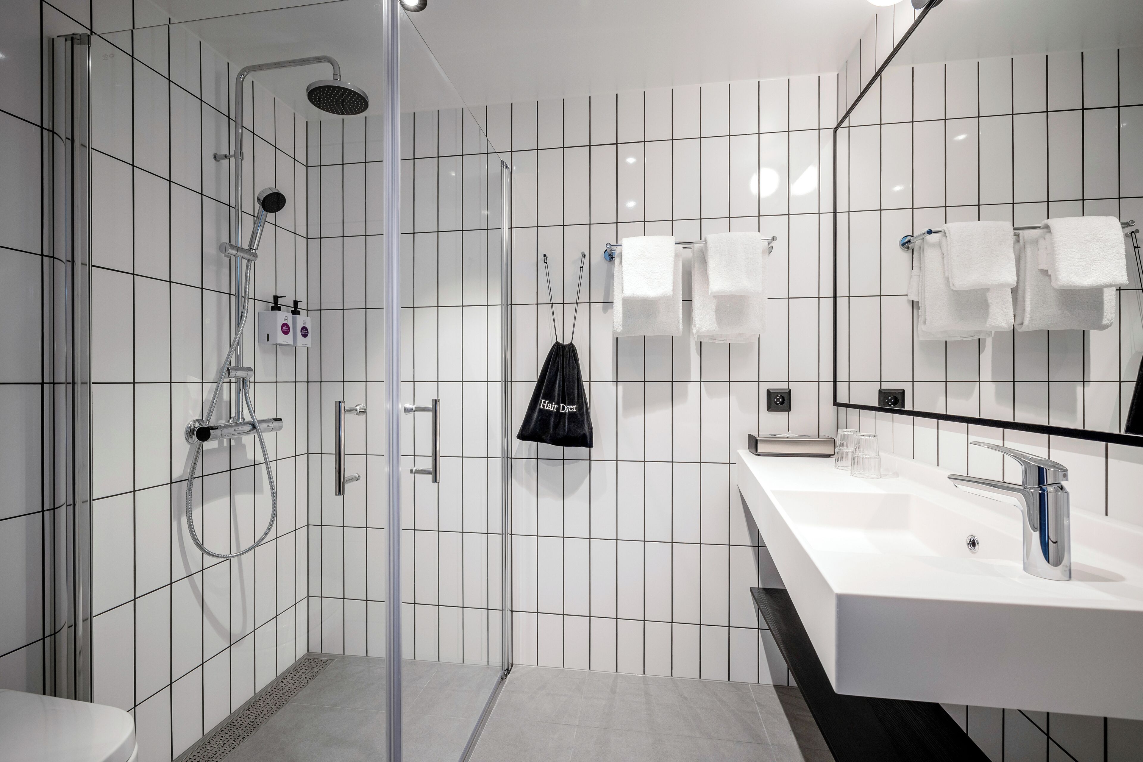 Une salle de bain moderne équipée d’une douche, de toilettes et d’un lavabo.