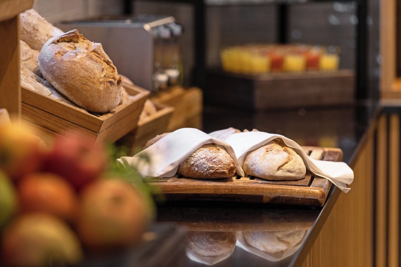 A bakery display with various breads and pastries.