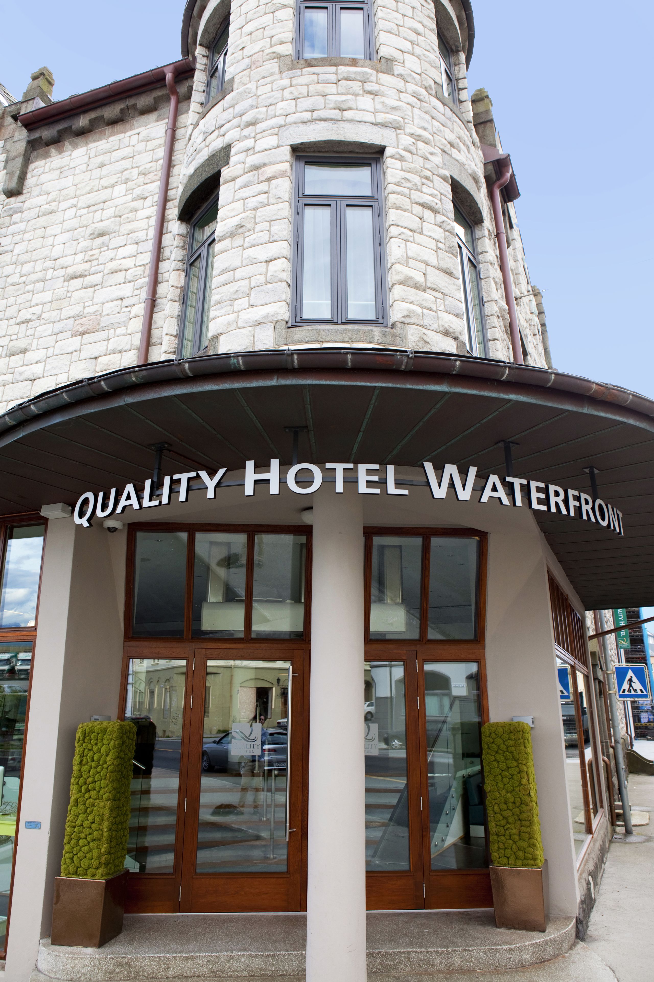 A stone building with a sign reading "QUALITY HOTEL WATERFRONT".