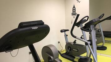 Ett gym med träningsutrustning, inklusive ett löpband och en crosstrainer.