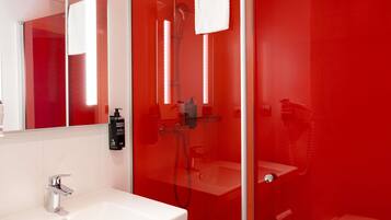 A modern bathroom with a glass-enclosed shower, a white sink, and a toilet.