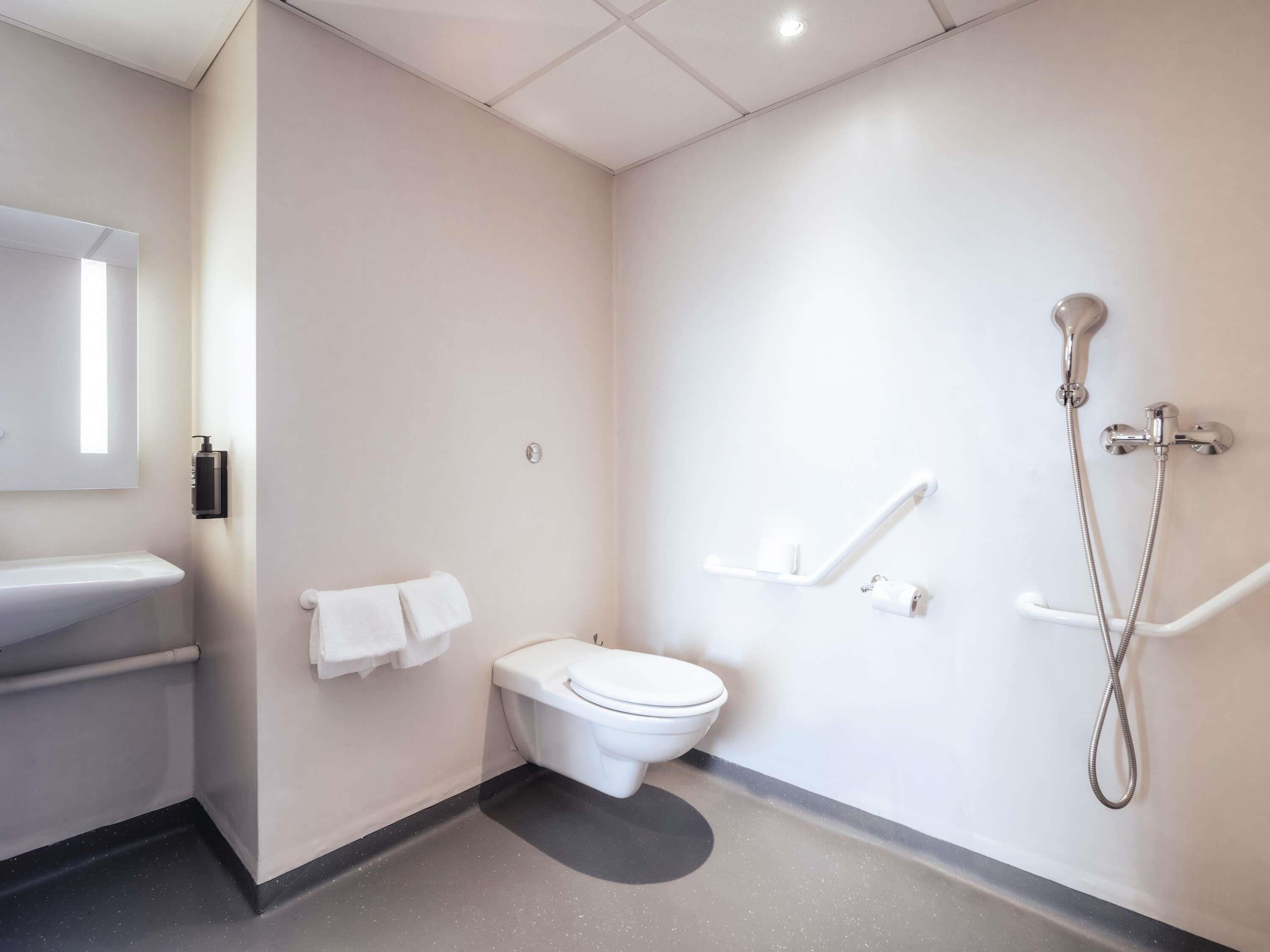 A modern bathroom with a toilet, sink, and shower.