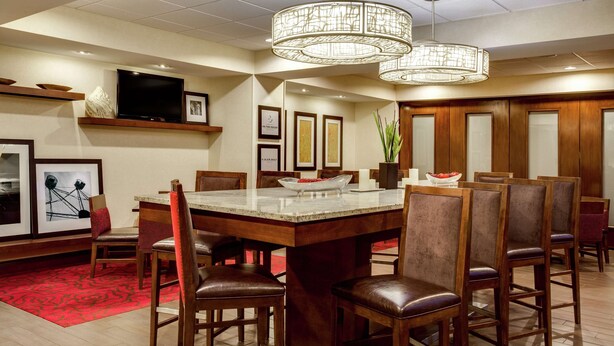Un comedor amplio con una isla grande, sillas de madera y una lámpara moderna.