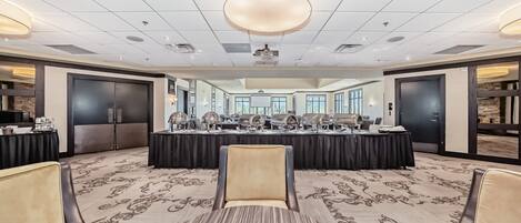 A conference room with a large table, chairs, and a carpeted floor.