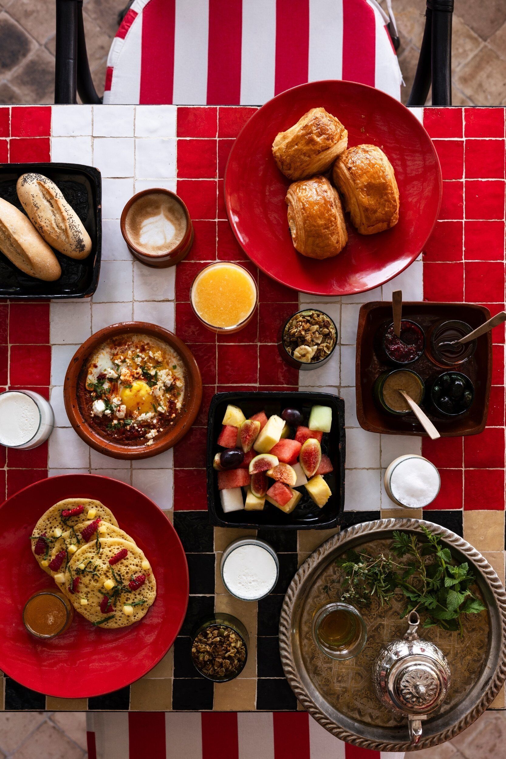 A table with various breakfast items including pastries, fruits, and beverages.