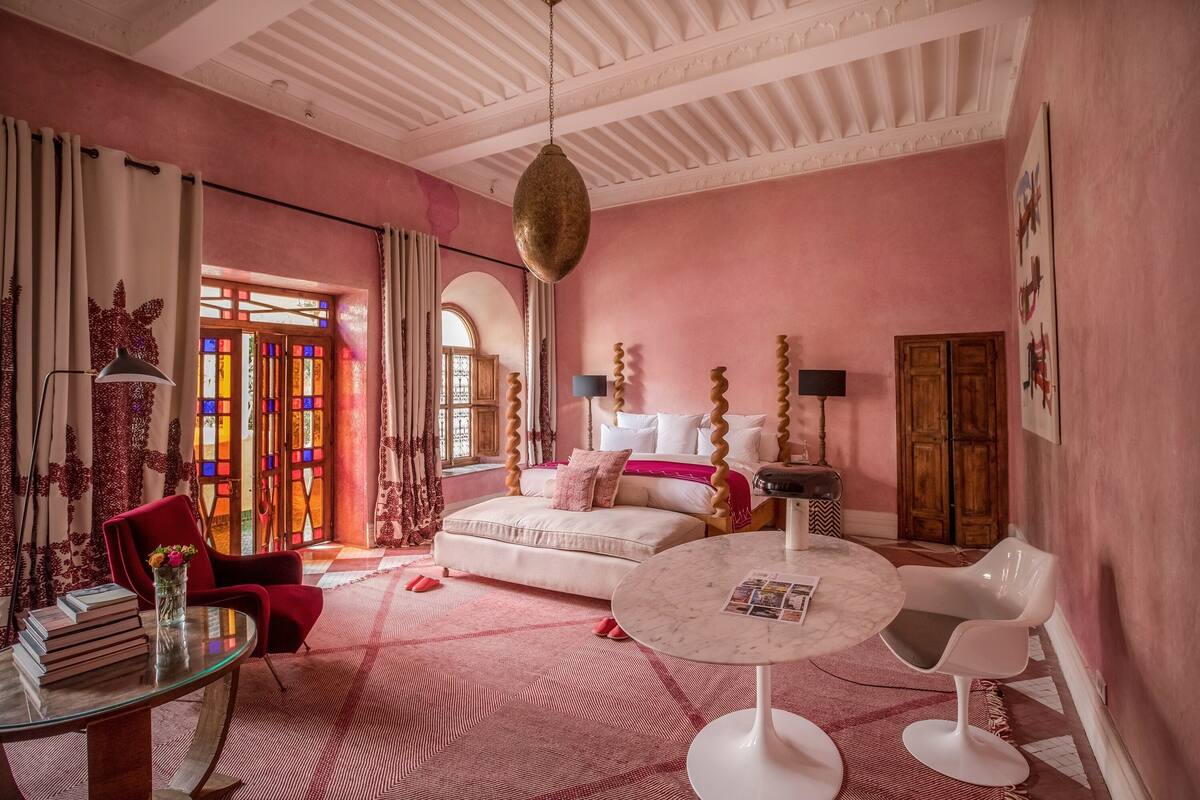 A room with a bed, a round table, a chair, and a sofa.