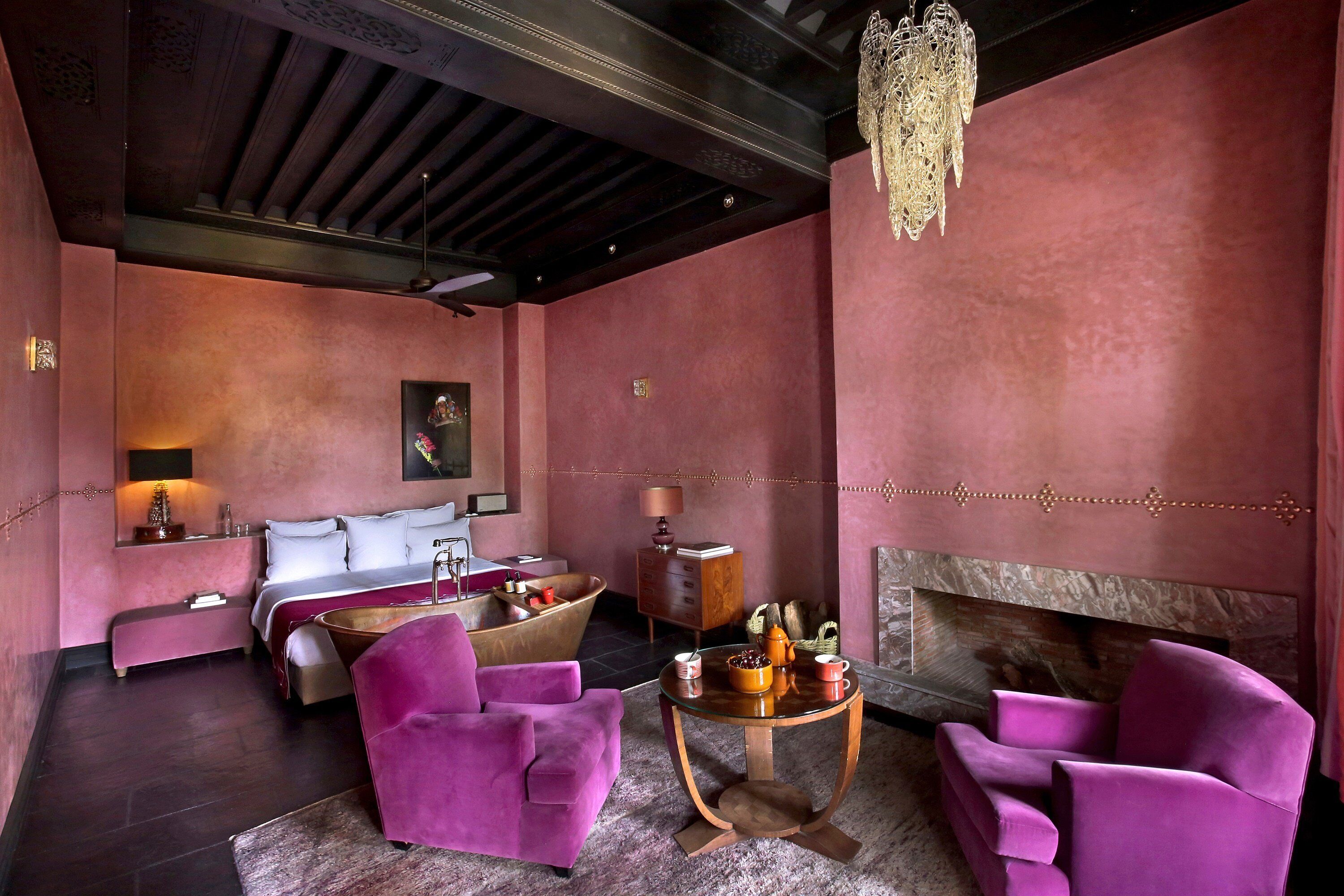 A modern living room with a sofa, armchairs, a coffee table, and a fireplace.