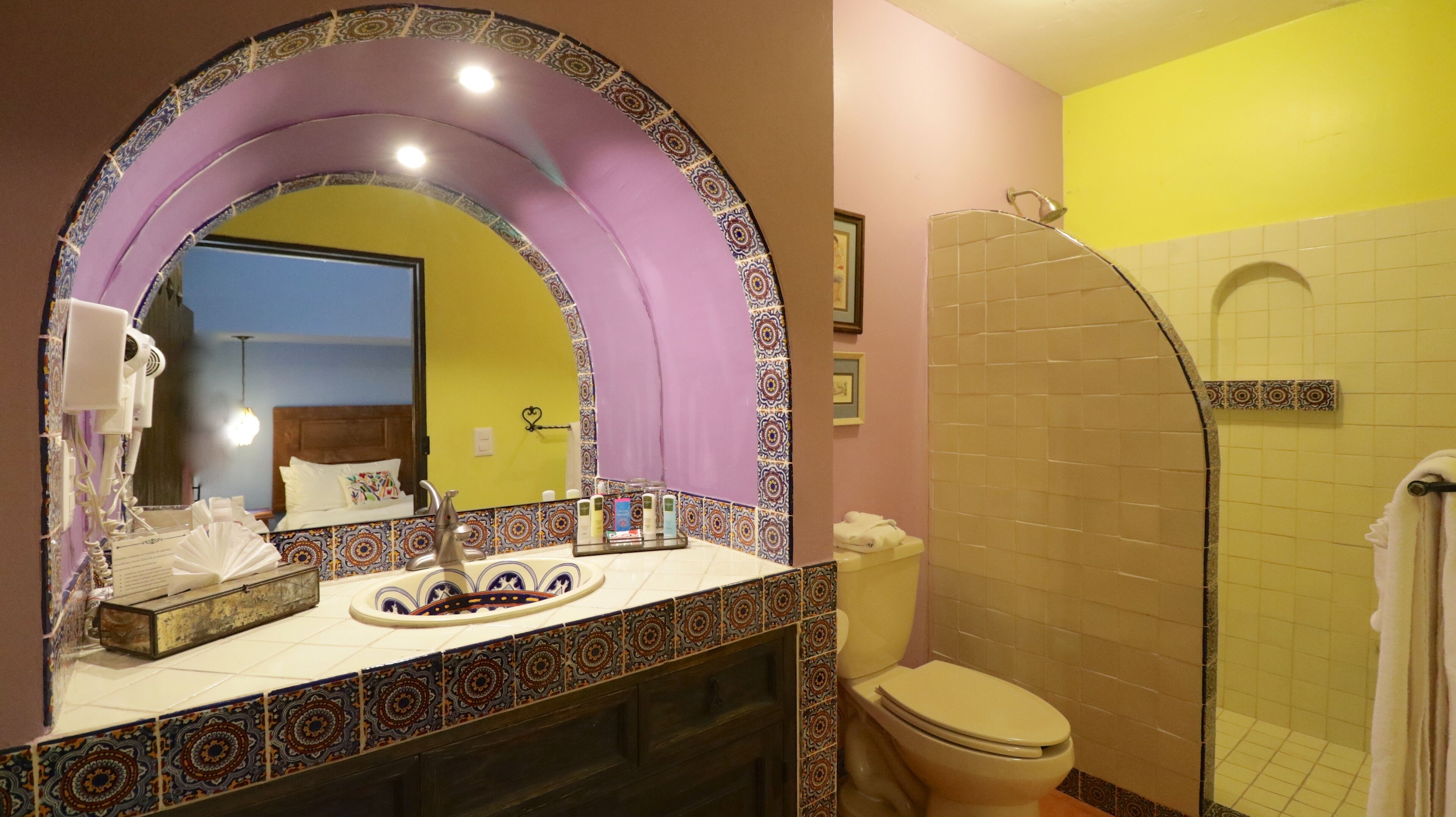 A bathroom with a vanity, a shower, and a toilet.