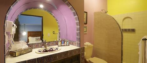 A bathroom with a vanity, a shower, and a toilet.