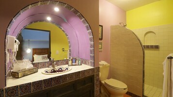 Un baño con tocador, ducha e inodoro.