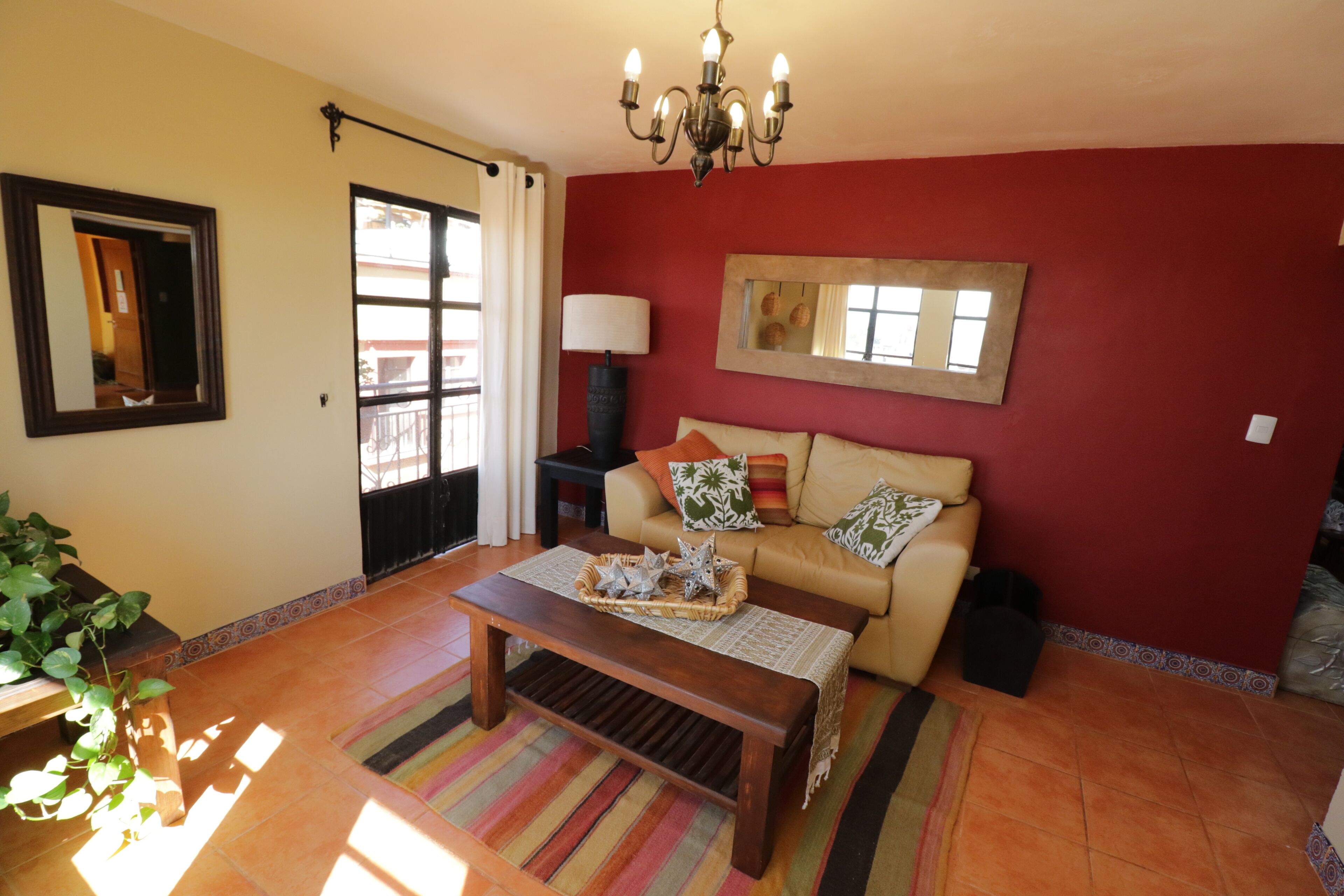 Una sala de estar con un sofá, una mesa de centro con una cesta, una lámpara y un candelabro.