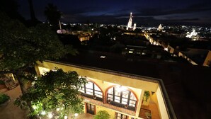 Ein Gebäude mit Innenhof, einer Springbrunnen und Blick auf eine nächtliche Skyline.