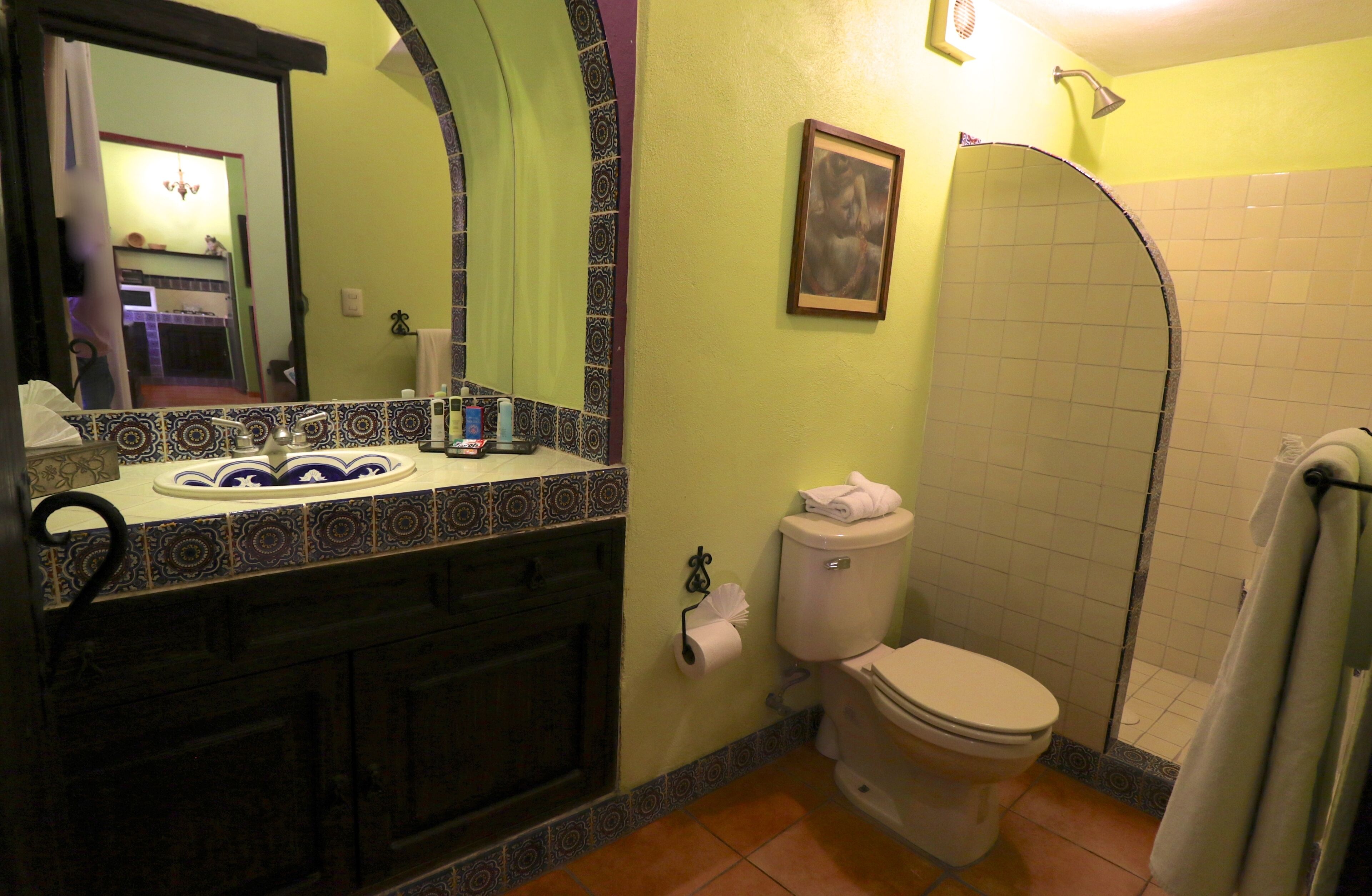 A bathroom with a toilet, sink, and shower.