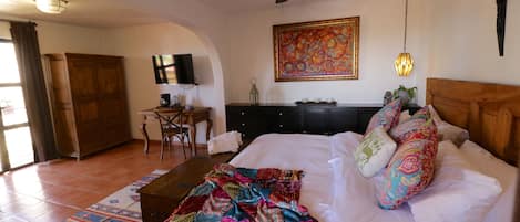 Un dormitorio con cama, escritorio, silla y ventilador de techo.