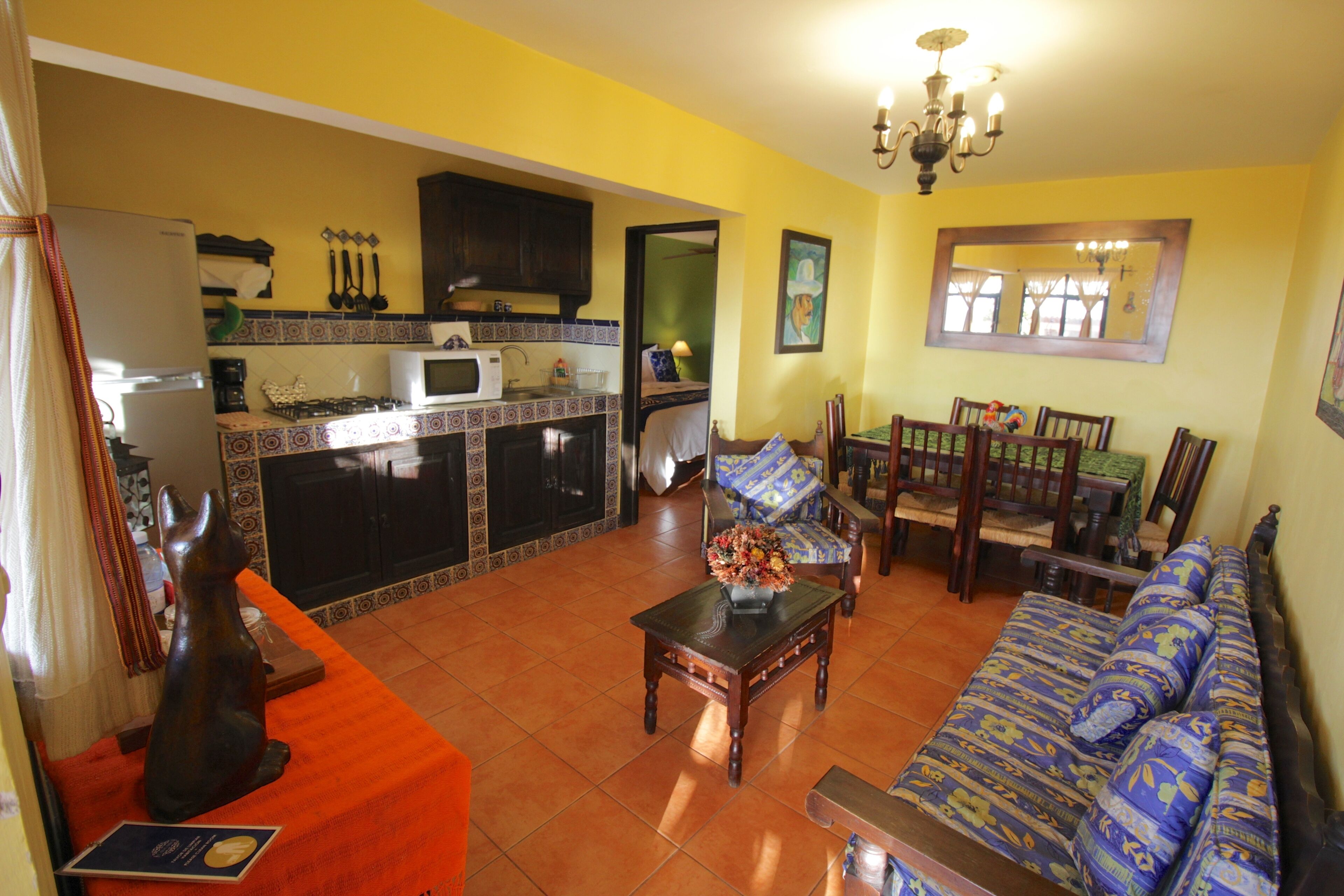 A living room with a sofa, a coffee table, and a dining area with chairs and a table.