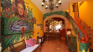 Ein lebendiger Innenraum mit Wandgemälde, einer Treppe und einer Bar.