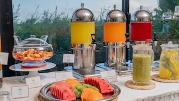 A buffet table with various food items and beverages.