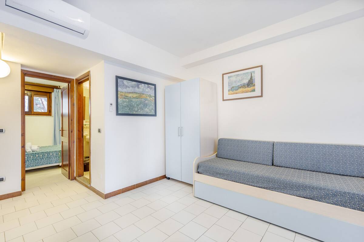 Un soggiorno moderno con un divano, un armadio e un quadro appeso al muro.
