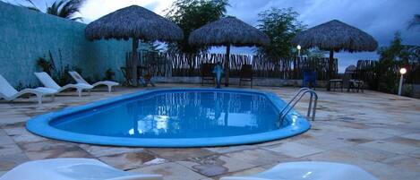 Een buitenzwembad, parasols voor strand/zwembad