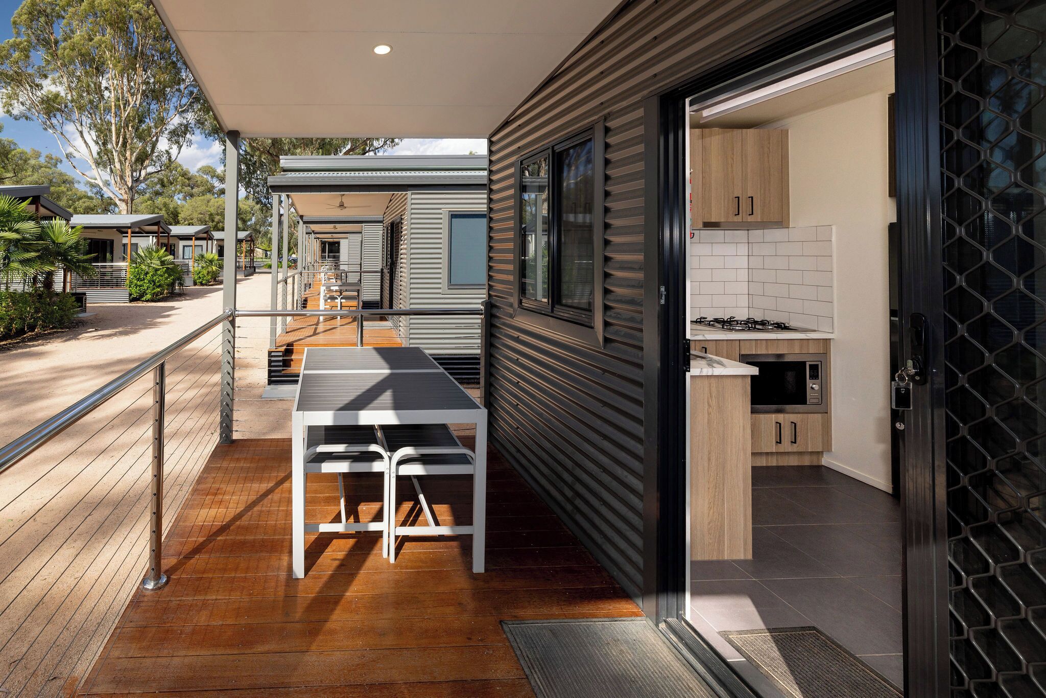 A modern kitchen with a wooden countertop, stainless steel appliances, and a view of the outdoors.