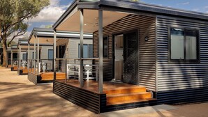 A modern RV-style accommodation with a covered porch, outdoor seating, and a visible number '43'. - Discovery Parks - Renmark Riverfront (Renmark)