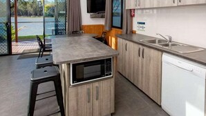 A modern kitchen with a built-in microwave, a dishwasher, and a large window overlooking a scenic view. - Discovery Parks - Renmark Riverfront (Renmark)