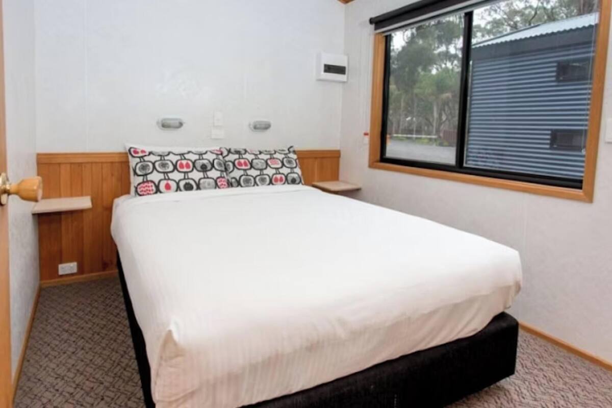 Un dormitorio con cama, ventana y puerta.
