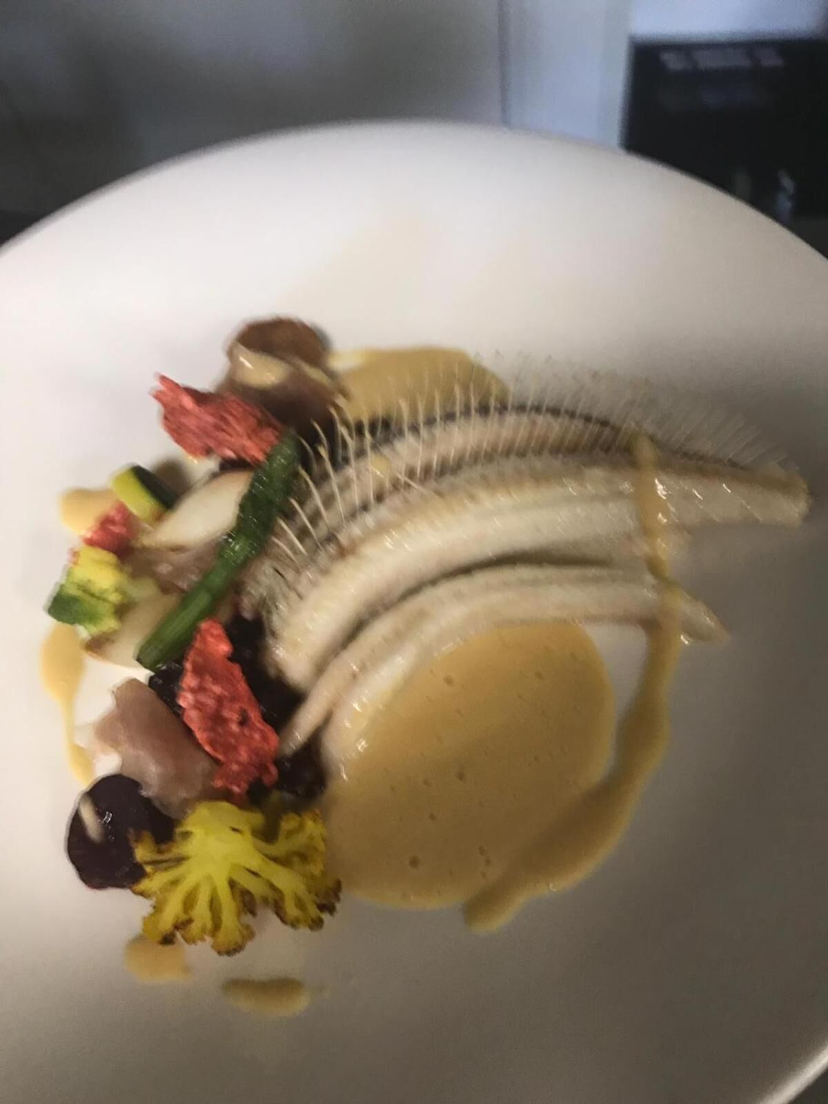 A plate of food with various vegetables and a sauce.