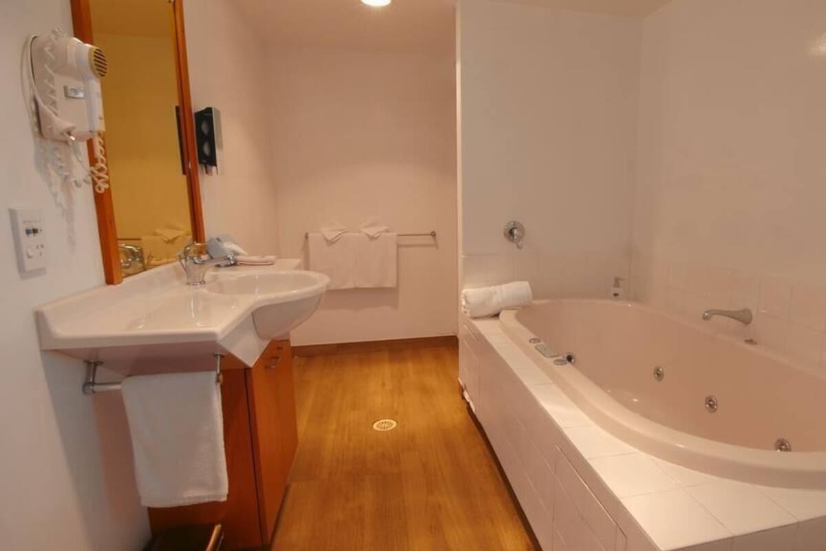 Ein Badezimmer mit Waschbecken, Spiegel und Badewanne.