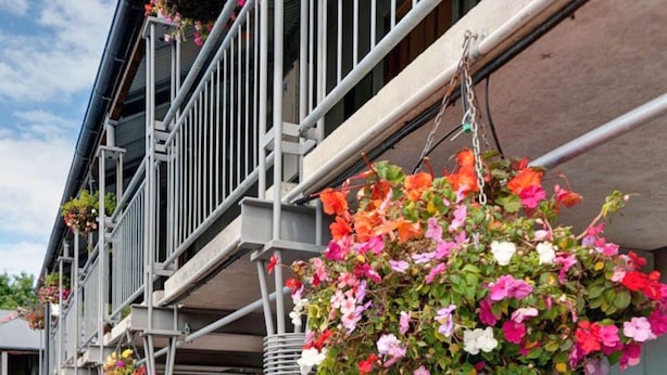 Un edificio con balcones decorados con macetas colgantes de flores.