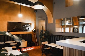 A restaurant interior with a bar area, seating, and a large wall-mounted artwork. - Design Hotel Jewel Prague (Prague)