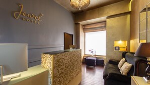 En hotellobby med modern design, inredd med en receptionsdisk, en soffa och en kristallkrona.