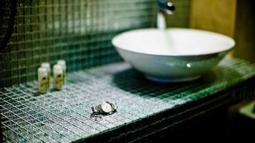 Un baño con un lavabo, un espejo y una encimera con patrón de cuadrícula.
