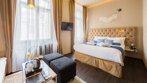 Ett modernt hotellrum med en stor säng, en platt-TV, ett sängbord och ett konstverk som hänger på väggen.