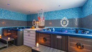 A spa area with two hot tubs, wooden benches, and candles. - Hotel Sun (Senec)