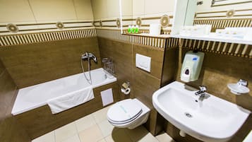 A bathroom with a bathtub, toilet, and sink.