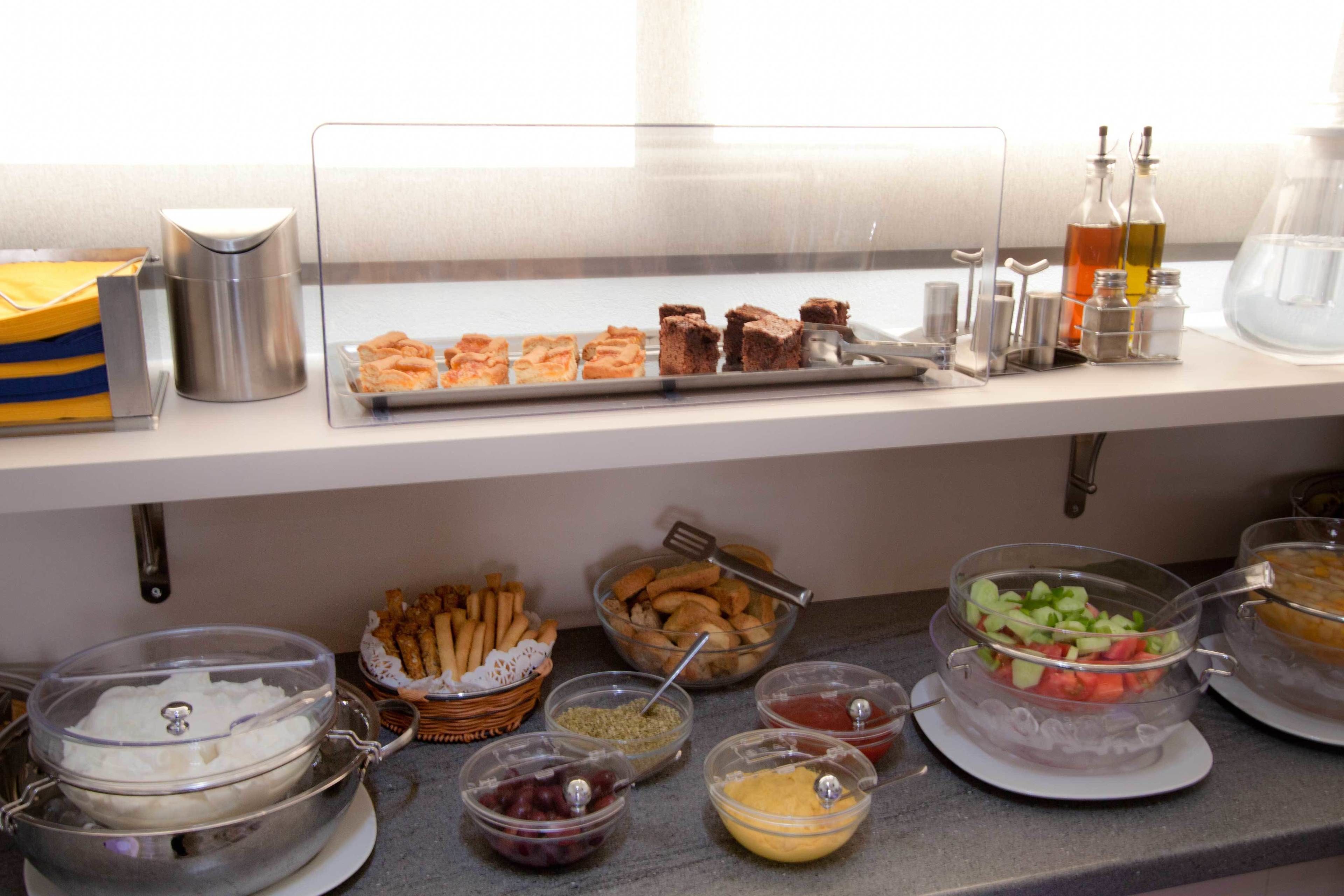 A buffet setup with various food items and condiments.