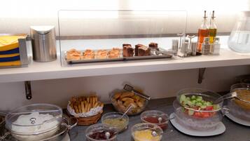 A buffet setup with various food items and condiments.