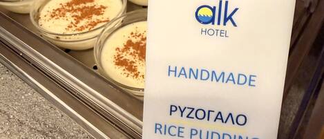 Ein Tablett mit selbstgemachtem Reispudding in Gläsern, mit einem Schild, das angibt, dass er vom Alk Hotel stammt.