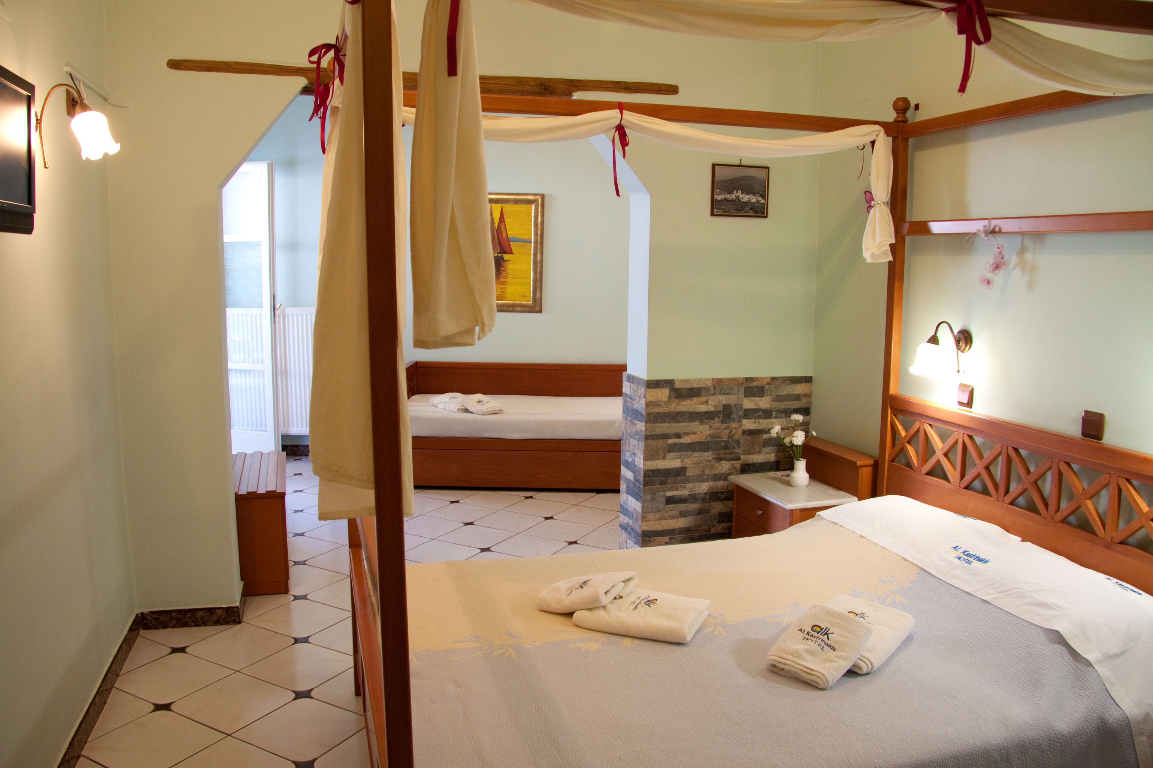 Un dormitorio con cama con dosel, cabecera de madera y pared de piedra decorativa.