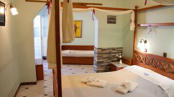 Un dormitorio con cama con dosel, cabecera de madera y pared de piedra decorativa.