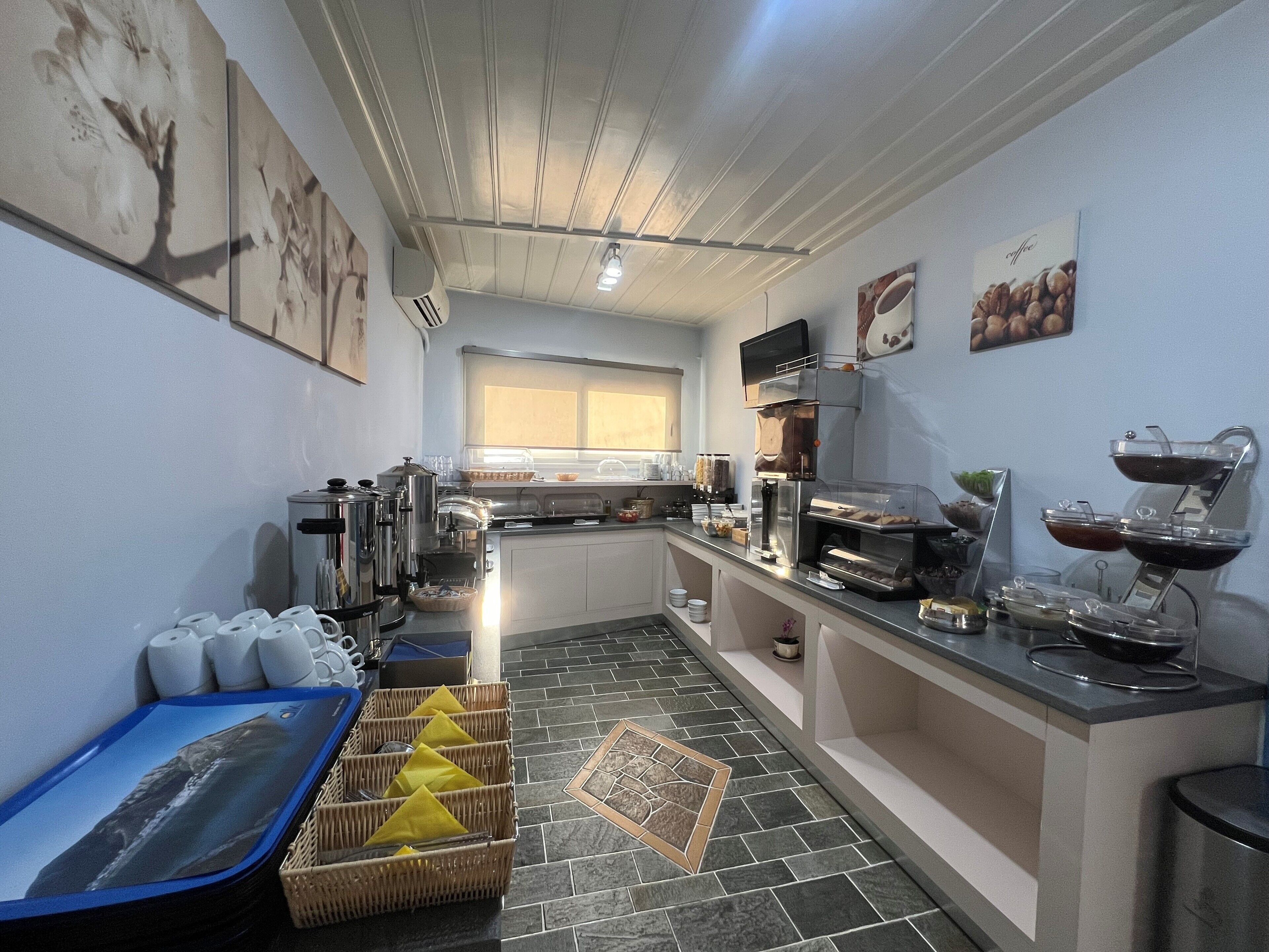 Una cocina moderna con una isla central, estación de café y ventana que proporciona luz natural.