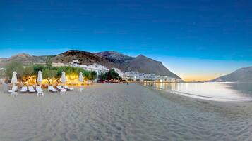 Una playa cerca, sombrillas, toallas de playa